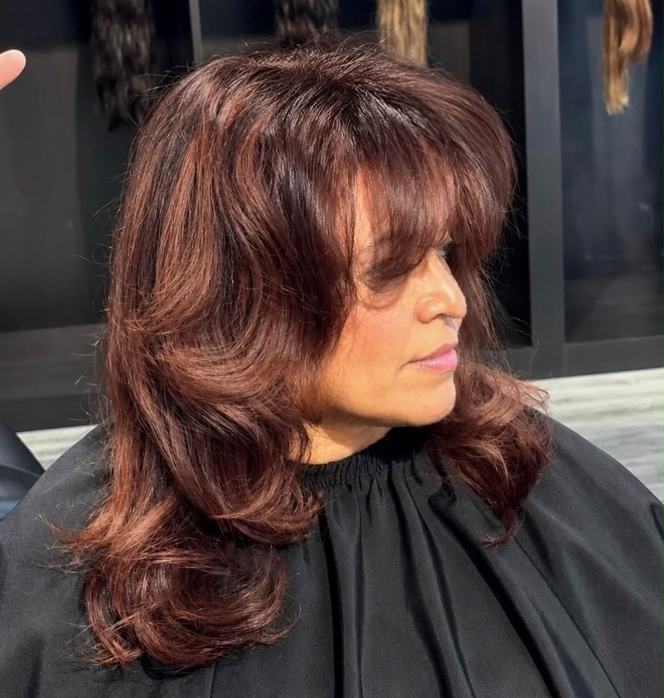 Koperrood gelaagd haar met volume, geföhnd in de salon